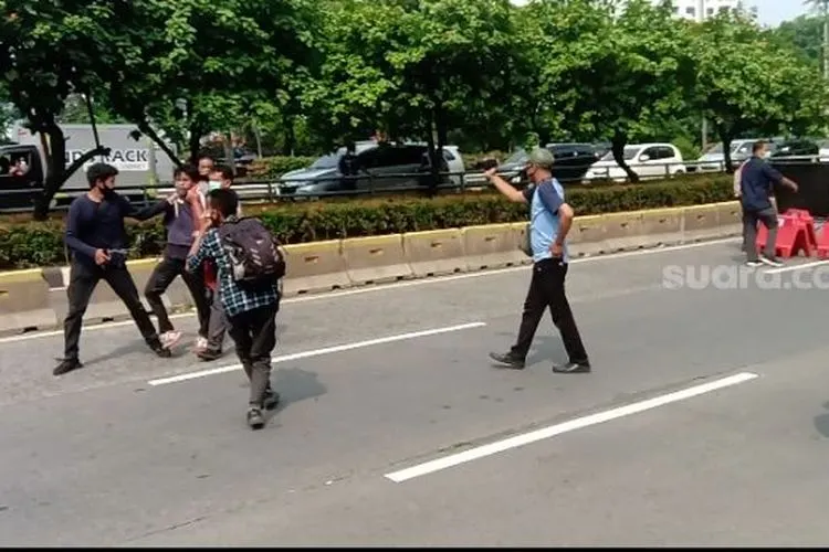 Aparat kepolisian berpakaian preman saat menangkap pendemo di kawasan DPR RI. (Suara.com/Arga)