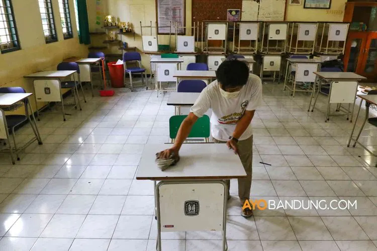 [ilustrasi] Petugas membersihkan meja dan ruangan kelas di SMA Negeri 3, Jalan Belitung, Kota Bandung, Selasa (9/6/2020). Selain bersih-bersih menggunakan cairan disinfektan, pihak sekolah juga mengatur jarak satu meter antarmeja dan kursi siswa sebagai antisipasi kegiatan mengajar dikelas dibuka kembali ditengah pandemi covid-19. (Ayobandung.com/Irfan Al-Faritsi)