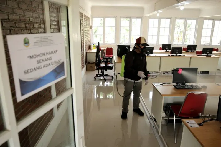 Petugas menyemprotkan cairan disinfektan di Sekolah Menengah Kejuruaan Negeri (SMKN) 13 Bandung, Jalan Sukarno-Hatta, Kota Bandung, Rabu (18/3/2020). Hal tersebut dilakukan guna mencegah penyebaran pandemi Covid-19 dilingkungan sekolah. (Ayobandung.com/Kavin Faza)