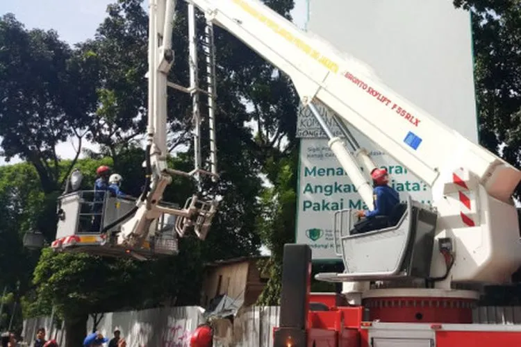 Proses evakuasi seorang pria yang memanjat tiang baliho / beritajakarta.id