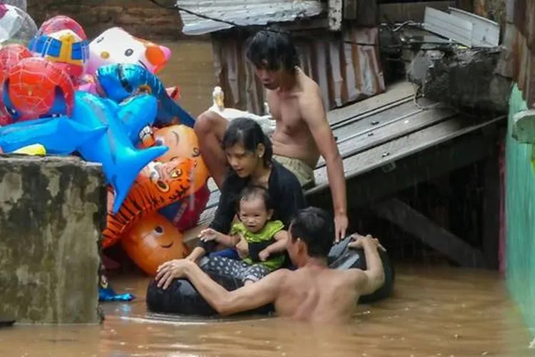 Warga dan anaknya korban banjir Jakarta sedang dievakuasi. (AFP/Bay Ismoyo)