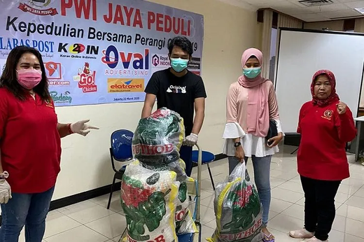 (dari kiri-ke kanan) Ketua PWI Jaya Peduli, Nonnie Rering, Ihsan dan Putri dari perwakilan RT 04/R 08 Petojo Binatu, Petojo Utara, dan pengurus PWI Jaya Peduli, Umi Sjariyah usai penyerahan paket bantuan di markas PWI Jaya, Jakarta Pusat, Senin (30/3/2020) (Humas PWI Jaya)