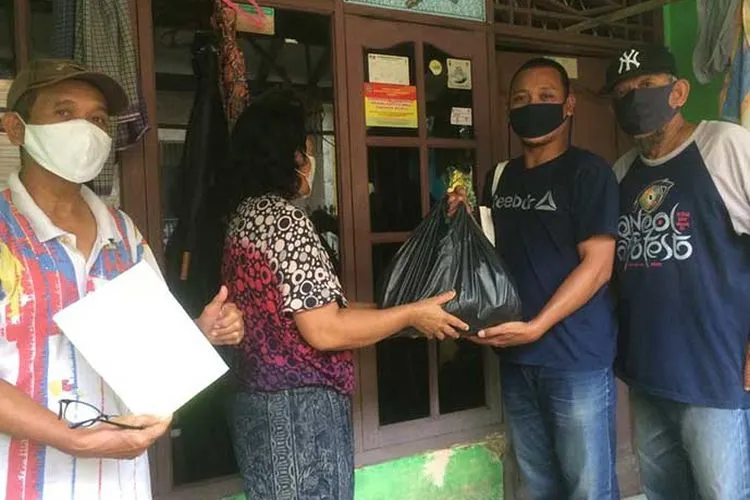 Ketua RW 14 Kelurahan Bekasi Jaya M Tahrir (paling kiri) saat menyerahkan bansos pada warga. (Dok M Tahrir )