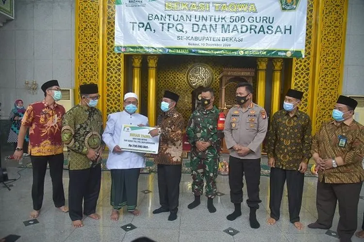 Bupati Bekasi Eka Supria Atmaja secara simbolis menyerahkan bantuan untuk masyarakat yang dikelola oleh Badan Amil Zakat Nasional (Baznas) Kabupaten Bekasi di Masjid Agung Nurul Hikmah, KomplekS Perkantoran Pemkab Bekasi, Cikarang Pusat, Kamis (10/12/2020). (dok)