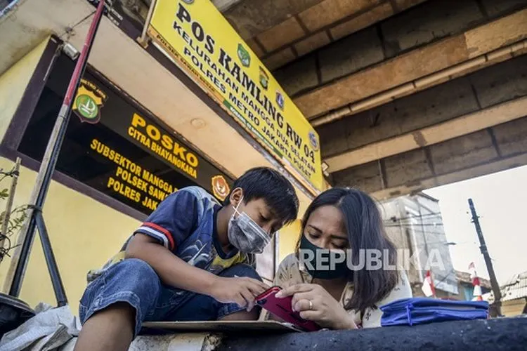 [ilustrasi] Seorang siswa saat belajar didampingi orang tuanya di kolong rel kereta api Mangga Besar, Jakarta, Rabu (26/8/2020). Para siswa memilih belajar di kolong rel karena terdapat modem paket internet wifi gratis yang disediakan untuk membantu mengikuti pembelajaran jarak jauh. Republika/Putra M. Akbar (FOTO : Republika/Putra M. Akbar)