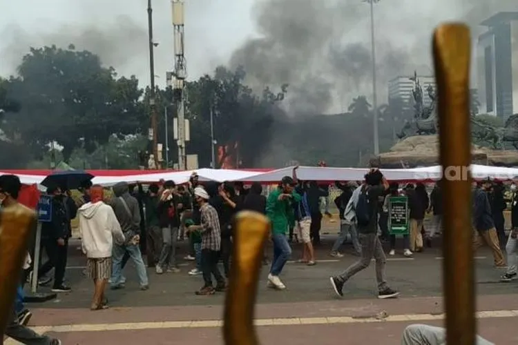 Bendara Merah Putih dibentangkan pendemo saat bentrok dengan aparat di kawasan Patung Kuda, dekat Istana Negara. (Suara.com/M Yasir).