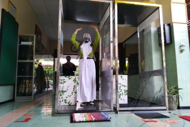 Siswa masuk ke bilik disinfektan dalam uji coba sekolah tatap muka di Kota Solo. (Ayojakarta/Budi Cahyono)