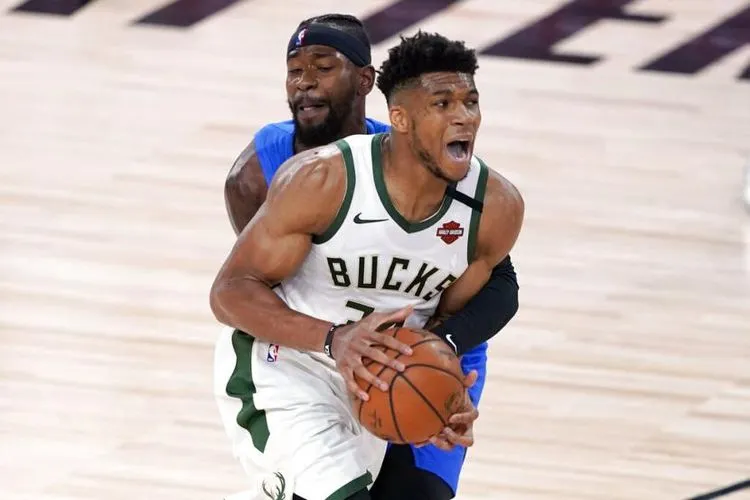 Bintang Milwaukee Bucks, Giannis Antetokounmpo, dipegangi oleh pemain Orlando Magic, Terrence Ross, dalam pertandingan play-off NBA, Minggu (30/8/2020) WIB. Foto: AP Photo/Ashley Landis