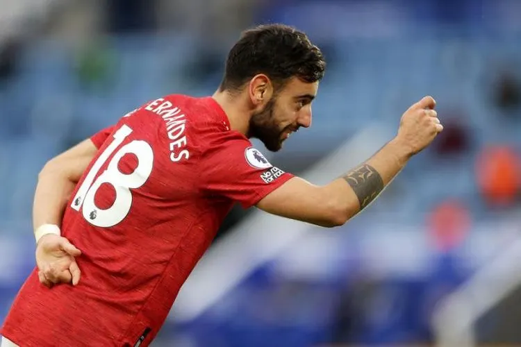 Gelandang serang Manchester United, Bruno Fernandes merayakan golnya. [CARL RECINE / POOL / AFP]