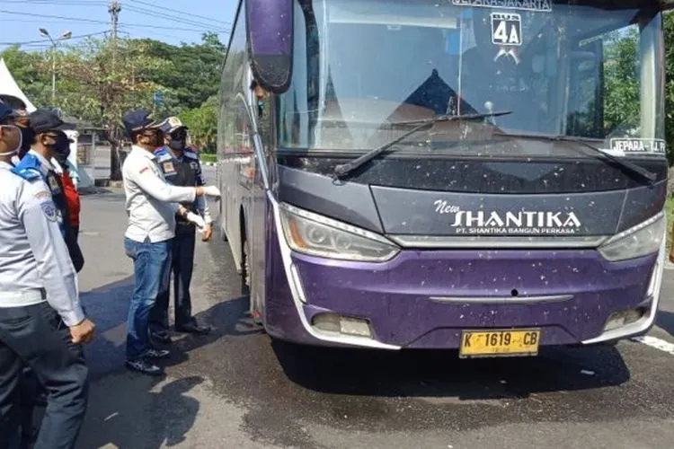 Petugas gabungan Pembatasan Kegiatan Masyarakat (PKM) menghentikan bus New Shantika saat hendak masuk ke Semarang di pos Mangkang, Jumat (1/5/2020). (dok).