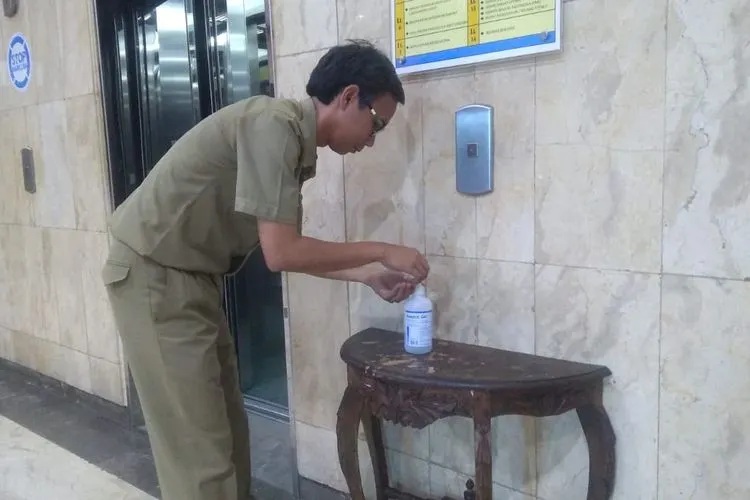 Seorang ASN di lingkungan Pemkot Jakarta Utara menggunakan fasilitas cairan antiseptik yang disediakan Bagian Umum Pemkot Jakut. (Dok. Pemkot Jakut)