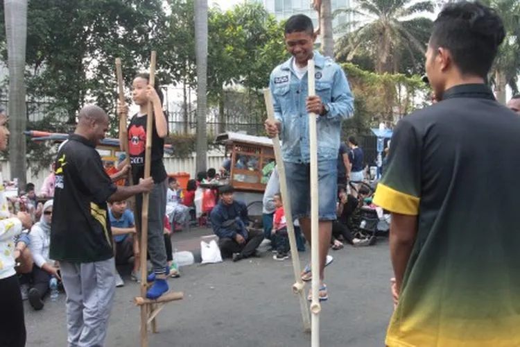Sejumlah anak bermain permainan tradisional dengan ditemani sejumlah mahasiswa dari 'Penggerak Olahraga' saat Car Free Day di kawasan Bunderan HI, Jakarta, Minggu (14/7/2019). Kegiatan rutin ini sebagai bentuk pengabdian untuk masyarakat untuk membuat masyarakat DKI Jakarta aktif berolahraga. ANTARA FOTO/Reno Esnir/ama.