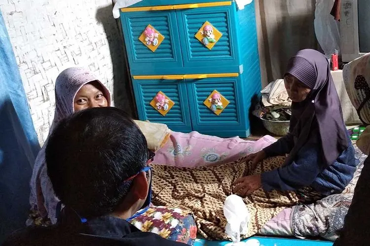 Salah satu warga yang terindikasi penyakit chikungunya  saat dikunjungi Kepala Desa Sukakarsa. (dok)
