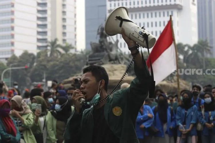 Seorang mahasiswa yang tergabung dalam Badan Eksekutif Mahasiswa Seluruh Indonesia (BEM SI) berorasi saat menggelar aksi unjuk rasa di kawasan Patung Kuda, Jakarta, Jumat (16/10/2020). [Suara.com/Angga Budhiyanto]