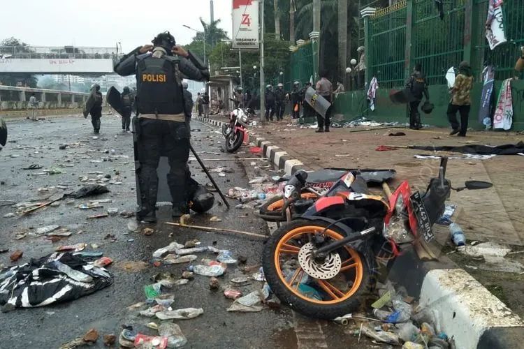 Aparat Polri tampak dari belakang setelah memukul mundur barisan mahasiswa dari depan gerbang utama Kompleks Parlemen, Senayan, Jakarta Pusat, dengan gas air mata dan meriam air (Selasa sore, 24/9/2019)/Ayojakarta.com