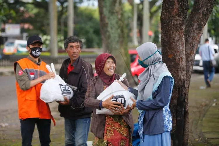 Ilustrasi penerima bantuan sosial -- Anggota komunitas Fotografer Muslim membagikan paket sembako pada warga yang membutuhkan, di Kota Bandung, Selasa (7/4/2020). (Ayobandung.com/Irfan Al Fartisi)
