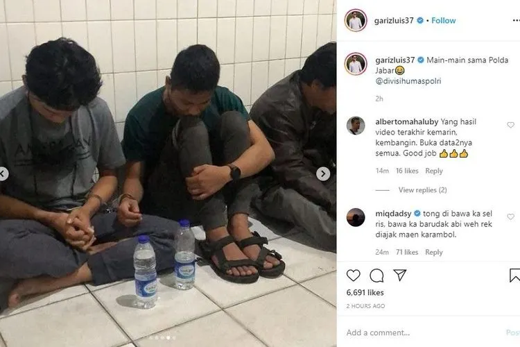 Ferdian Paleka (kiri), YouTuber  terlihat tertunduk saat dimintai keterangan polisi dengan tangan terborgol.[Instagram/garizluis37]