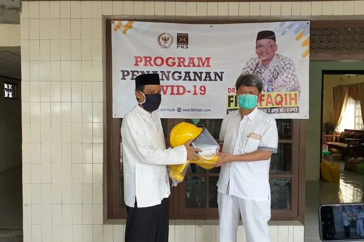 Anggota DPR, Abdul Fikri Faqih menyerahkan alat pelindung diri (APD) yang diterima secara simbolis oleh Direktur RSUD dr. Soeselo Slawi,  dr. Guntur Muhammad Taqwin.