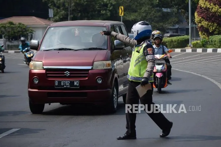 Petugas kepolisian mengamankan kendaraan roda empat di kawasan perluasan ganjil genap Jalan Majapahit, Jakarta, Senin (9/9/2019).  Foto: Thoudy Badai