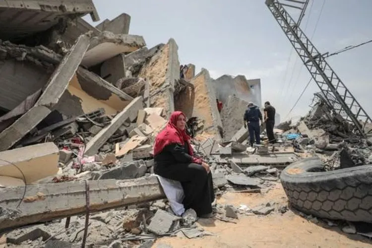 Warga Palestina mengais barang-barang di antara reruntuhan bangunan yang hancur akibat gempuran militer Israel di Kota Gaza/Anadolu Agency
