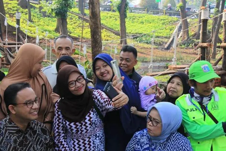 Gubernur Anies Baswedan melayani warga yang meminta foto bersama di Taman Kembang Kerep/barat.jakarta.go.id