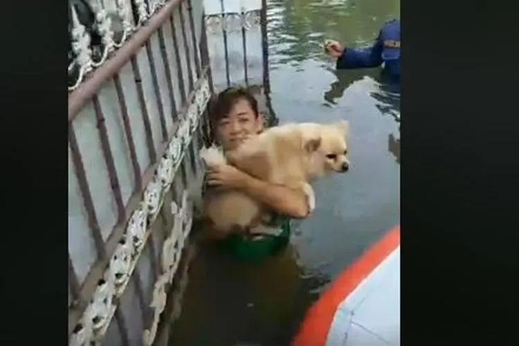 Warga korban musibah banjir di Perumahan Green Ville, Jakarta Barat, menyerahkan hewan peliharaannya kepada petugas penyelamatan. (Facebook Kompas.com)