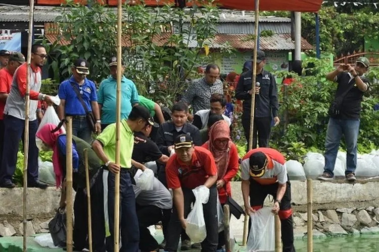 Wakil Wali Kota Jaktim Uus Kuswanto menebar benih ikan nila di Situ Rawa Badung (timur.jakarta.go.id)