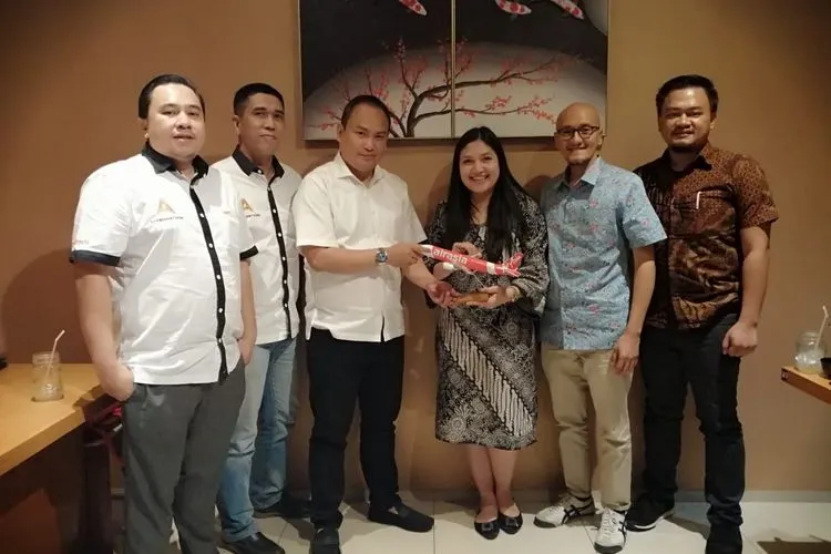 Direktur Utama Ayo Media Network Hilman Hidayat (Ketiga kiri) menerima cendera mata dari Group Head Communication AirAsia Audrey Progastama Petriny di salah satu rumah makan di Kota Bandung, Senin (15/7/2019).