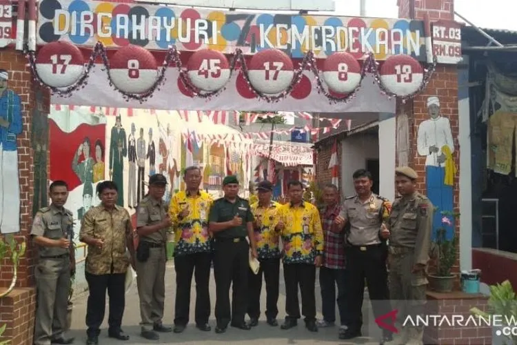 Tim penilai dari unsur Muspika bersama warga Kalideres, Jakarta Barat, berpose di depan gapura perbatasan kampung yang telah dihias warga dalam rangka memeriahkan HUT Ke-74 Republik Indonesia. (ANTARA/Andi Firdaus).