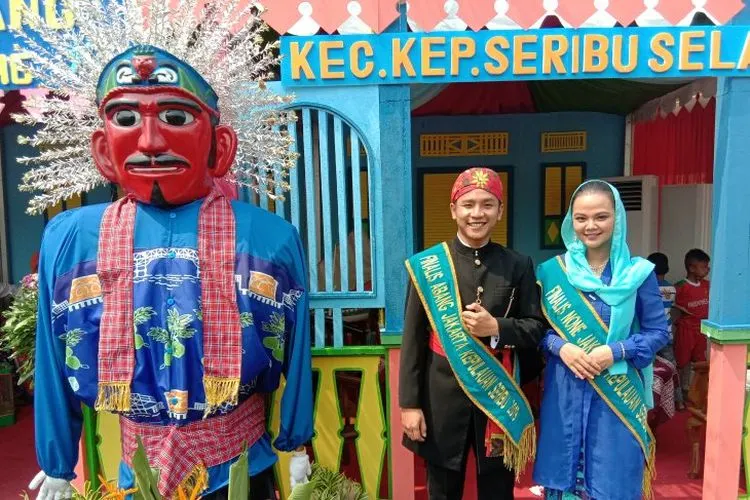 Finalis abang dan nona Kepulauan Seribu berfoto bersama ondel-ondel yang mengenakan pakaian batik bermotif Jembatan Cinta dan daun sukun dalam acara Lebaran Betawi di Monumen Nasional, Jakarta Pusat, Sabtu (20/7/2019). (ANTARA/Sugiharto Purnama)