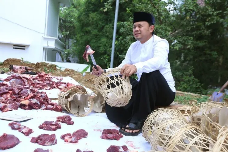 Wali Kota Bogor Bima Arya membungkus daging kurban menggunakan bongsang. (ayobogor.com)