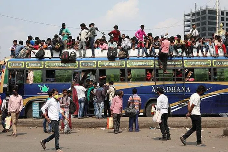 Penumpang menaiki bus yang penuh sesak untuk kembali ke kampungnya sebelum dimulainya lockdown oleh pemerintah negara bagian Bengal Barat untuk membatasi penyebaran penyakit coronavirus (COVID-19), di Kolkata, India, Selasa (23/3/2020). (REUTERS/Rupak De Chowdhuri)