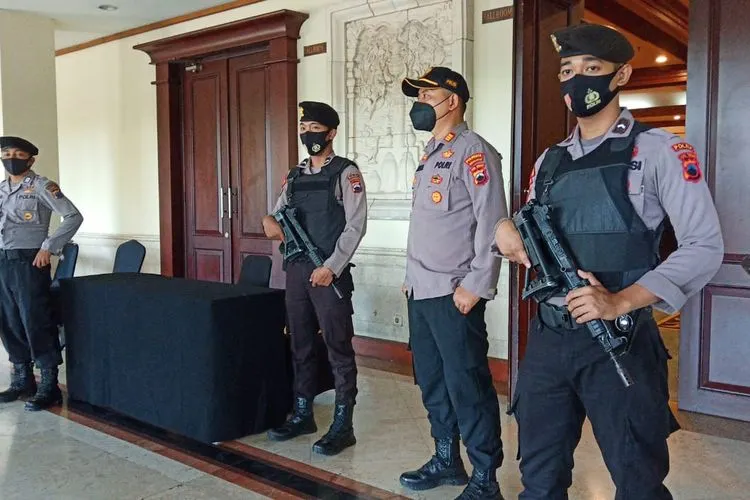Polisi bersenjata lengkap berjaga di pintu masuk ruangan untuk pengundian dan penetapan nomor pasangan calon Pilwakot Solo, di Hotel Sunan, Solo, Jawa Tengah, Kamis (24/9/2020). (ist)