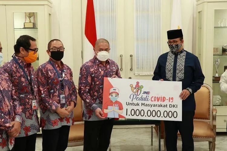 Presiden Direktur JNE, M. Feriad menyerahkan bantuan donasi Rp 1 miliar kepada Gubernur DKI Jakarta, Anies Baswedan di Balai Kota, Jakarta Pusat, Jumat (24/4/2020) (Media Relations Dept. JNE)