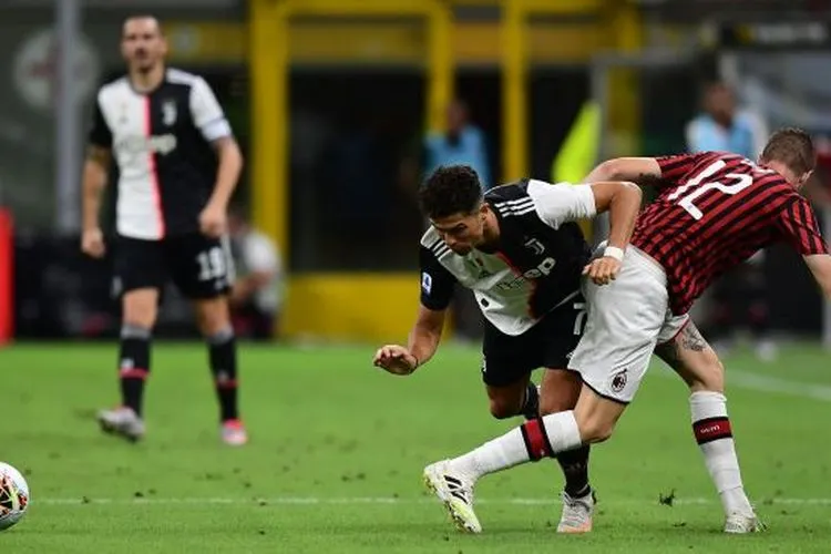 Pemain depan Juventus Cristiano Ronaldo bertabrakan dengan bek AC Milan Andrea Conti selama pertandingan sepak bola Serie A Italia AC Milan melawan Juventus di Stadion San Siro, Milan, Rabu (8/9) dini hari WIB. [Miguel MEDINA / AFP]