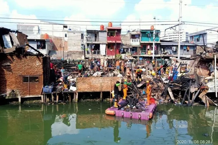 Petugas kebersihan bersama warga sedang membersihkan puing-puing rumah di Jalan Raya Tanjung Selor, Kelurahan Cideng, Gambir, Jakarta Pusat, pada Minggu (8/11/2020) pagi. Sebanyak 20 rumah di kawasan pemukiman padat penduduk itu terbakar pada Sabtu (7/11/2020).  Foto: Pemkot Jakpus