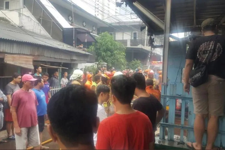 Warga tengah membantu petugas memadamkan kebakaran rumah warga yang berada di belakang Kuningan City (TMC Polda Metro Jaya)