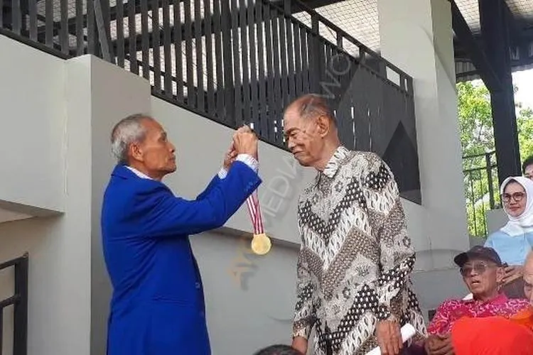 Plt. Ketum PAMI Merari Nainggolan mengalungkan medali kepada Koptu Marinir (Purn) Soetiyo/Ayojakarta.com