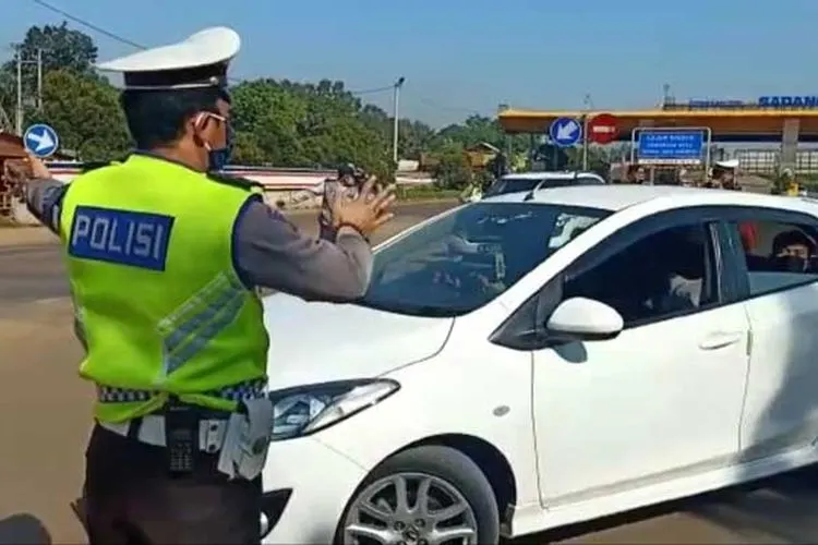 Petugas Kepolisian saat mengintruksikan kendaraan putarbalik di GT Sadang, Purwakarta. (dok)