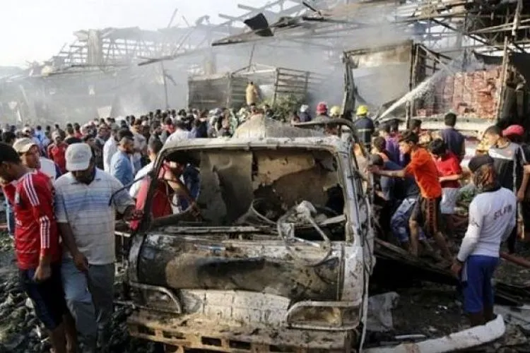 Warga berkumpul di bekas lokasi ledakan bom di tengah pasar yang sibuk di Baghdad (Reuters)