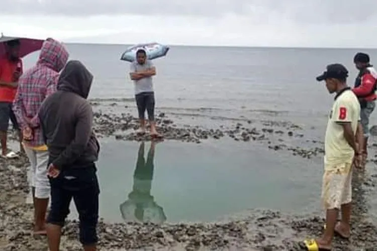 Sejumlah warga di Desa Liang, Kecamatan Salahutu, Pulau Ambon, melihat lubang-lubang sebesar sumur yang muncul di pantai desa mereka, Sabtu (28/9/2019)/Kompas.com -foto dok Ibrahim
