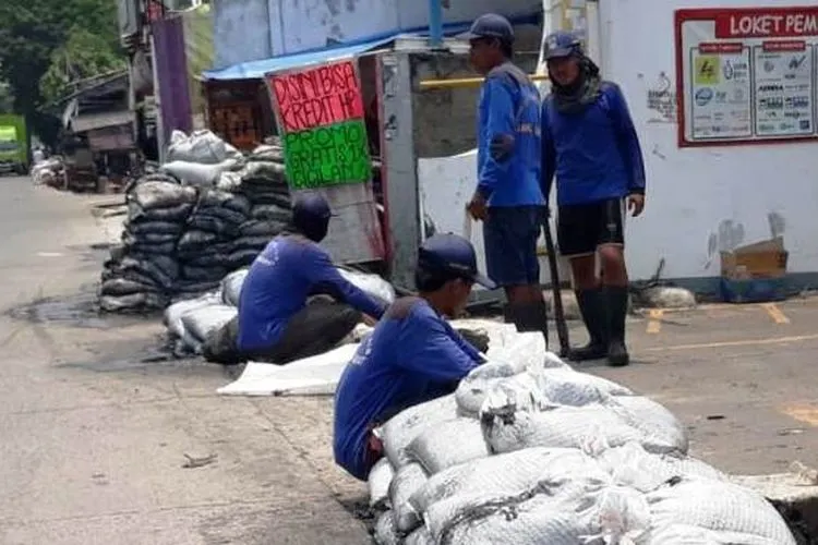 Petugas membersihkan endapan lumpur di saluran Phb Jalan Sulaiman/barat.jakarta.go.id