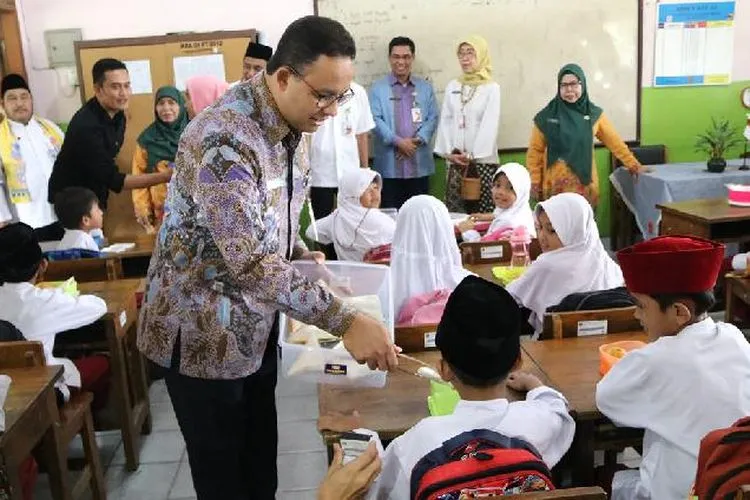 Gubernur DKI Jakarta Anies Baswedan membagikan makanan kepada siswa SD dalam Program Penyediaan Makanan Tambahan Anak Sekolah/Dokumentasi Pemprov DKI