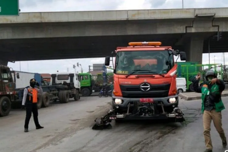 Petugas membersihkan ceceran tanah merah di Jalan Akses Marunda, Cilincing/dok: beritajakarta.id