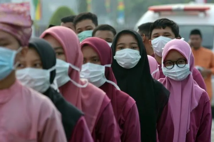 Sejumlah peserta upacara peringatan HUT ke-62 Provinsi Riau mengenakan masker medis akibat asap menyelimuti Kota Pekanbaru, Jumat (9/8/2019). Provinsi Riau pada usianya yang ke-62 masih dibayangi masalah lingkungan khususnya kebakaran hutan dan lahan yang mengakibatkan polusi asap, karena berdasarkan data Kementerian Lingkungan Hidup dan Kehutanan (KLHK) luas kebakaran di Riau sejak Januari tahun ini sudah lebih dari 27 ribu hektare. ANTARA FOTO/FB Anggoro/foc.
