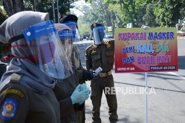 Satuan Polisi Pamong Praja (Satpol PP) Jawa Barat, menggelar sosialisasi kepatuhan penggunaan masker di depan Gedung Sate, Jalan Diponegoro, Kota Bandung, Rabu (29/7/2020). Kegiatan tersebut dilakukan sebagai bentuk tanggung jawab Satol PP, yang tergabung dalam Gugus Tugas, dalam meningkatkan kesadaran masyarakat dalam menerapkan protokol kesehatan di masa Adaptasi Kebiasan Baru (AKB) di Jawa Barat. (FOTO : Edi Yusuf/Republika)