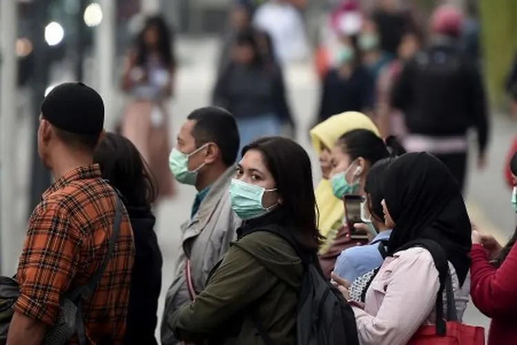 Ilustrasi--Sejumlah pejalan kaki menggunakan masker ketika melintas di kawasan Jalan Jenderal Sudirman, Jakarta, Kamis (25/7/2019). Dinas Lingkungan Hidup DKI Jakarta akan meningkatkan layanan angkutan umum massal, mulai dari MRT dan kendaraan umum massal lainnya, menyediakan perlengkapan uji emisi kendaraan bermotor dan penambahan ruang hijau terbuka serta penanaman pohon yang dapat menyerap polutan seperti PM 2,5 di udara yang dikeluarkan sebagian besar oleh asap pembuangan kendaraan bermotor. ANTARA FOTO