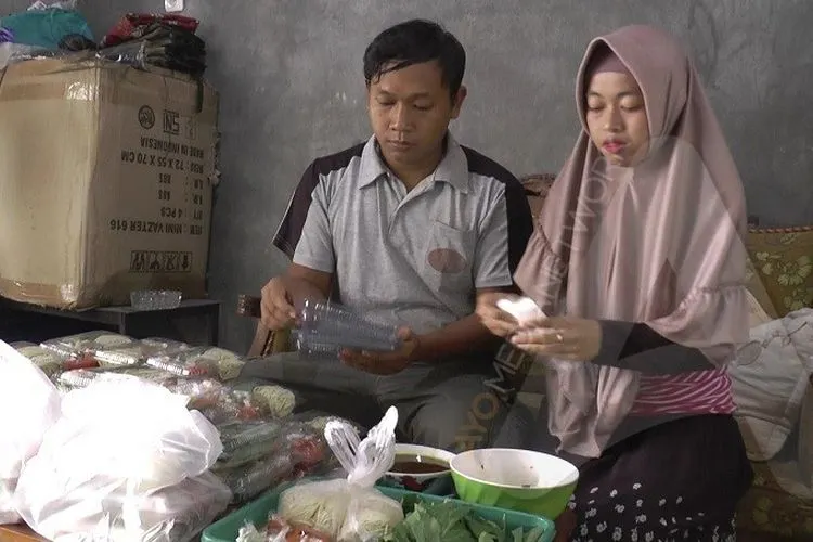 Muhamad Khoirul Daru dan istrinya mengemas mi keriting dan sayuran dalam satu wadah untuk dijual ke pembeli. Khoirul berinovasi membuat mie ayam mentah setelah di-PHK dari perusahaannya akibat dampak korona. (Ayosemarang.com/Edi Prayitno)