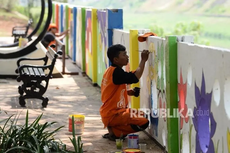 Petugas PPSU kelurahan Pondok Bambu membuat mural di tembok halte sepeda kawasan Banjir Kanal Timur (BKT), Jakarta, Rabu (20/11). (Foto: Republika/Prayogi)