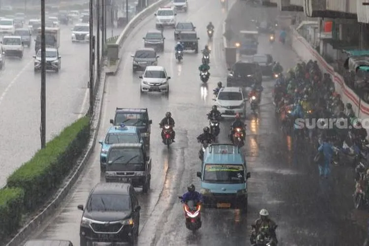 Suasana arus lalu lintas di Jalan Gatot Subroto saat dilanda hujan deras siang ini di Jakarta, Senin (26/10). [Suara.com/Alfian Winanto]